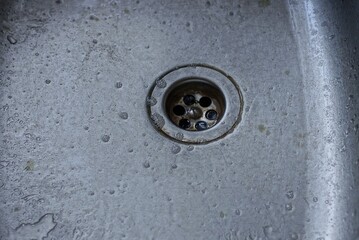 part of a gray metal wet sink with a round spout in the kitchen