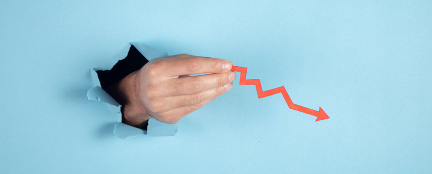 man hand holding falling red chart arrow