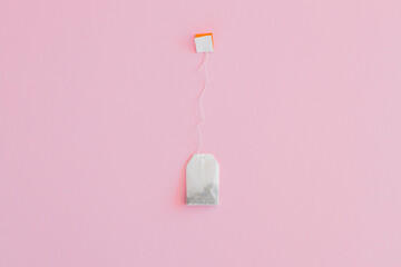 Tea bag with label on pink background, space for text