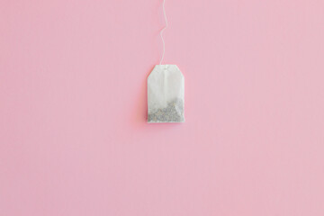 Tea bag with label on pink background, space for text