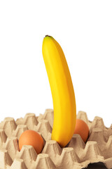 Big ripe banana and two chicken eggs in egg carton on white background. Sexy concept.