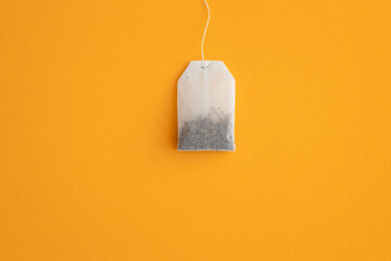 Tea bag with label on yellow background, space for text
