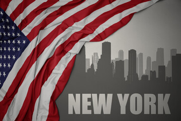 abstract silhouette of the city with text New York near waving national flag of united states of america on a gray background.