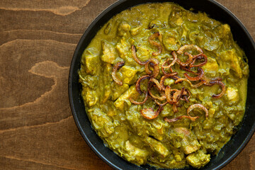 Turkey meat in coriander chutney with fried onion. Indian cuisine dish.