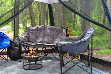 soft comfortable chairs, wine and propane firepit under mesh canopy needed for comfort in camping...