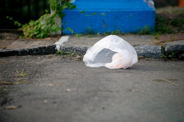 Carelessly thrown away white plastic bag on the street in a city