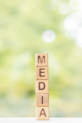 Media is written on wooden cubes on a green summer background Closeup of wooden elements
