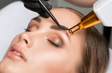 Removal of permanent makeup on the eyebrows.Carbon face peeling in a beauty salon. Hardware cosmetology treatment.