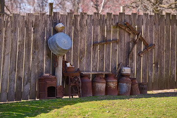 rusty cans for water and milk near the fence