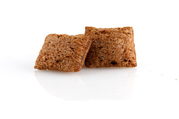 Set of chocolate pillows for breakfast isolated on white background. Brown choco cereal pads with vanilla, crispy flakes, healthy sweet snack. Close-up