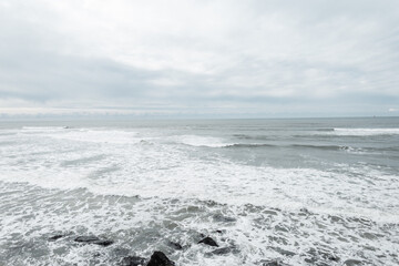 Exuberant ocean with waves and a cloudy gray sky. Traveling in Portugal. Sea view