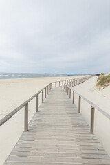 Fototapeta na wymiar Beautiful sandy beach with a wooden walkway by the sea