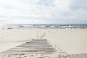 Fototapeta na wymiar Beautiful ocean scenery with white sand and a wooden walkway to the ocean