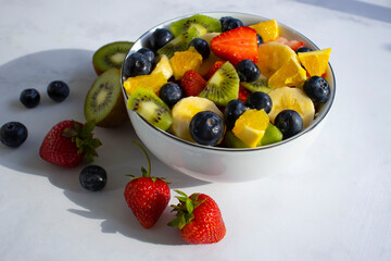 Plate with fruit salad on a light background