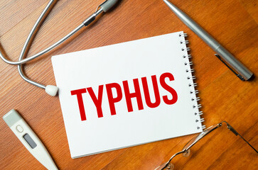 sheet of paper with the text typhus and stethoscope. Medical concept
