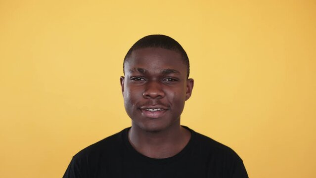 Man portrait. Smiling attractive gazing winking guy with flirty expression isolated on orange background.