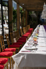 Fototapeta na wymiar Sun glare in crystal or glass goblets and glasses of different color. Expensive interior for luxurious wedding. Birthday dinner on outdoors. Soft focus