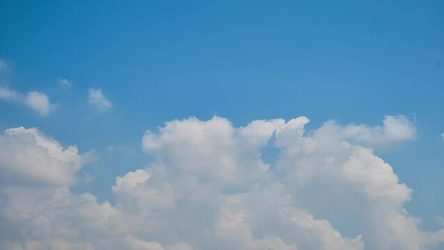 Time lapse of puffy clouds moving opposite blue sky. Clouds and bright blue sky timelapse