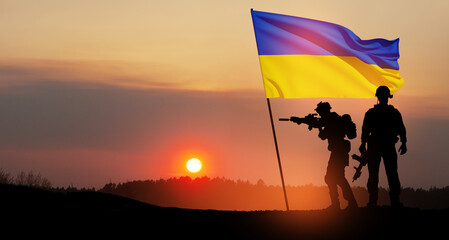 Flag of Ukraine with silhouette of soldiers against the sunrise or sunset. Concept - armed forces...