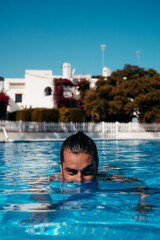 Naklejka premium Young man relaxing in swimming pool