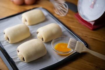 spreading egg yolk on chocolate croissants, pastry image