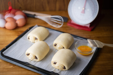 spreading egg yolk on chocolate croissants, pastry image