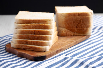 Slices of White Bread on a Rustic Wooden Board, side view.