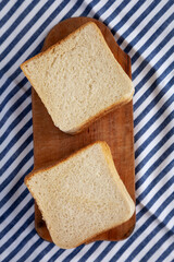 Slices of White Bread on a Rustic Wooden Board, top view. Flat lay, overhead, from above.