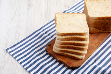 Slices of White Bread on a Rustic Wooden Board, side view. Space for text.