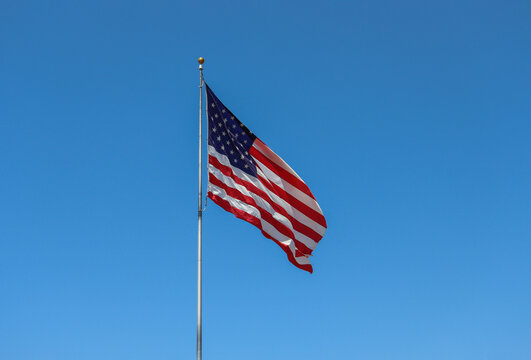 The American flag with a deep blue sky background.