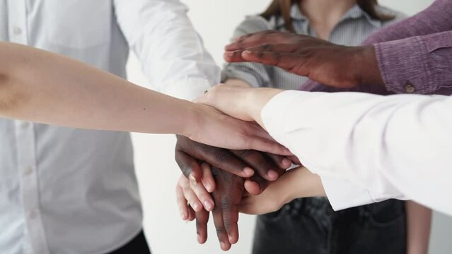 Teamwork business. Diverse partnership. Multiracial cooperation. Closeup of mixed race partners team hands joining together in stack unity symbol.