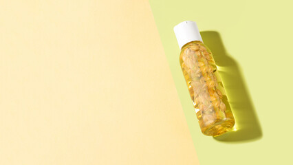 A bottle of jasmine essential oil lying on a light green background. Cosmetic essential oil for...
