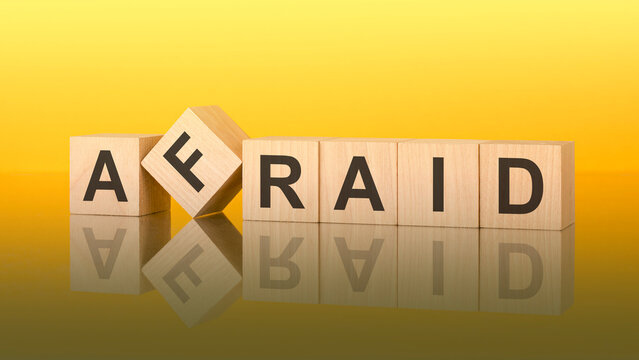 afraid word is made of wooden blocks lying on the yellow table, concept