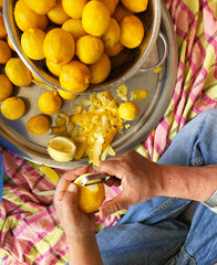 Obraz premium man peeling lemon with peeler. preparing traditional homemade lemonade. 