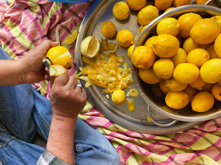 man peeling lemon with peeler. preparing traditional homemade lemonade. 