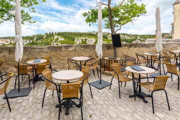 An outdoor cafe overlooking the Alpilles mountains and the valley of Les Baux in Les Baux-de-Provence, in the Provence region of Southern France. 