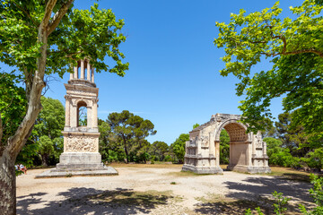 Fototapeta na wymiar The ancient Roman Mausoleum of the Julii alongside the triumphal arch at the historic Glanum archaeological site near Saint-Remy-de-Provence in the Provence region of Southern France.