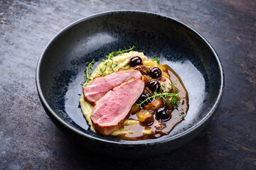 Barbecue gourmet duck breast filet with polenta, caramelized mushrooms and amarena cherry in hearty...