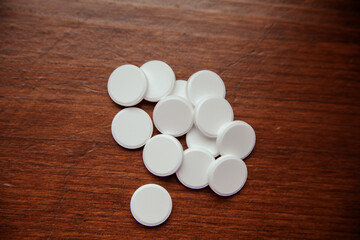 Fototapeta na wymiar Tablets are scattered on a dark wooden table. Background for pharmacy, antibiotics, vitamins. drug pills
