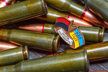 7.62 mm rifle bullets.Fabric curved flag of Ukraine, UA. Blue and yellow colors.Ukraine patch on army uniform.Stop war.Patriotism.Democracy and politics. Close up shot, background