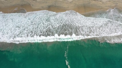 Obraz na płótnie Canvas 2020:LOS CABOS MEXICO.Green Ocean Water Waves Crash Into White Foam As They Crash Upon Sandy Beach