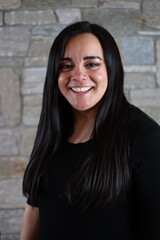 woman in black standing in front of stone wall