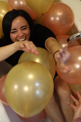 cheerful woman surrounded by balloons at a party