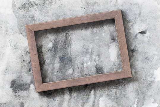 Wooden photo frame on background of gray painted wall