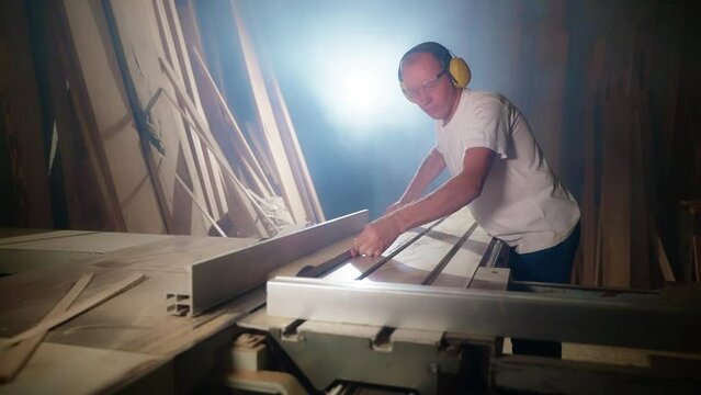 Wooden board rip cuts with a table saw. Carpenter at work