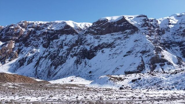 drone tour of the imposing snowy mountain in the andes mountain range on a cold sunny day in winter season