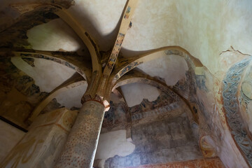 Remains of antique Romanesque frescoes on walls, ceiling and supporting pillar in ancient Church of...