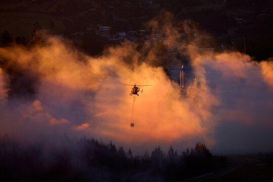 Smokey sunset and helicopter fighting fire at Burnside, Dunedin, South Island, New Zealand
