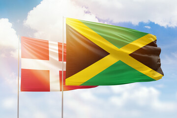 Sunny blue sky and flags of jamaica and denmark