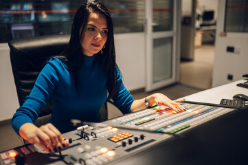 Fototapeta premium Middle aged woman using equipment in control room on a tv station